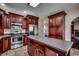 Kitchen with stainless steel appliances, island, tile floors, and custom wood cabinetry at 1585 Brookgreen Dr., Myrtle Beach, SC 29577