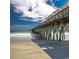 Beautiful shot of a pier extending over a sandy beach into the crystal-clear ocean at 1585 Brookgreen Dr., Myrtle Beach, SC 29577