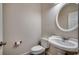 Bathroom with pedestal sink, toilet, round mirror, and tile flooring at 1585 Brookgreen Dr., Myrtle Beach, SC 29577