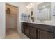 Double sink bathroom with a white countertop and dark wood cabinets, and access to the walk-in closet at 160 Ocean Commons Dr., Surfside Beach, SC 29575