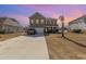 Two-story home with a spacious driveway, palm tree, and colorful sunset at 160 Ocean Commons Dr., Surfside Beach, SC 29575