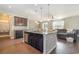 Bright open-concept kitchen with an island and stainless steel dishwasher connecting to the living room and dining area at 160 Ocean Commons Dr., Surfside Beach, SC 29575