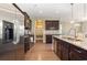 Well-lit kitchen featuring dark wood cabinets, stainless steel appliances, granite countertops, and a view of the dining area at 160 Ocean Commons Dr., Surfside Beach, SC 29575