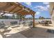 An outdoor patio space featuring cushioned chairs and a covered pergola sits next to an additional seating and hot tub area at 160 Ocean Commons Dr., Surfside Beach, SC 29575