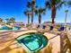 A sunny outdoor pool deck featuring a long pool, a hot tub, and a view of the ocean at 1625 S Ocean Blvd. S # 910, North Myrtle Beach, SC 29582