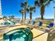 A sunny outdoor pool deck featuring a long pool, a hot tub, and a view of the ocean at 1625 S Ocean Blvd. S # 910, North Myrtle Beach, SC 29582