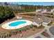 Aerial view of the community pool, clubhouse, and pond in a tranquil, wooded setting at 179-A Parmelee Dr. # A, Murrells Inlet, SC 29576