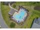 Aerial view of a community pool with blue umbrellas and ample lounge chair seating at 182 Tibton Circle, Myrtle Beach, SC 29588