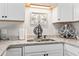 Close-up of the kitchen sink area featuring granite countertops, white cabinets, and stylish fixtures at 1891 Colony Dr. # 15-G, Surfside Beach, SC 29575