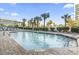 Outdoor pool with clear blue water surrounded by lounge chairs and tropical palm trees at 2001 S Ocean Blvd. # 209, Myrtle Beach, SC 29577