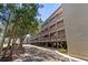 Multi-story condo featuring covered parking underneath building with mature shade trees and landscaping at 207 3Rd Ave. N # 348, North Myrtle Beach, SC 29582