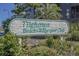 Charming Tilghman Beach & Racquet Club sign amidst lush greenery, welcoming residents and guests at 207 3Rd Ave. N # 348, North Myrtle Beach, SC 29582