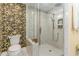 A modern bathroom with a glass enclosed shower and decorative wallpaper at 233 Banbury Ln. # 302, Little River, SC 29566