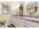 A well-lit bathroom with a double vanity, granite countertops and decorative mirrors at 233 Banbury Ln. # 302, Little River, SC 29566