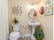 A pedestal sink bathroom with an artistic tree decoration at 233 Banbury Ln. # 302, Little River, SC 29566