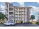 Exterior view of a multi-story building showcasing its balconies, parking, and architectural design elements at 233 Banbury Ln. # 302, Little River, SC 29566