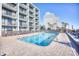 Outdoor pool and surrounding deck with views of nearby buildings and palm trees at 2401 S Ocean Blvd. # 359, Myrtle Beach, SC 29577