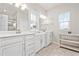 Bright bathroom with double sinks, white cabinets, large mirrors and natural light from a window at 2609 Turchino Ct., Myrtle Beach, SC 29579