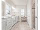 Bright bathroom with double sinks, white cabinets, large mirrors and natural light from a window at 2609 Turchino Ct., Myrtle Beach, SC 29579