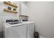 Well-lit laundry room with modern washer, dryer, shelves, cabinet and wallpaper at 2815 Eclipse Dr., Myrtle Beach, SC 29577