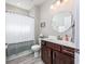 Bathroom with wood vanity, framed mirror, tiled floors, a shower curtain and modern fixtures at 3105 White Jasmine Dr., Little River, SC 29566