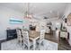 Open dining room with hardwood floors, modern light fixture, and a view into the living room and kitchen at 3105 White Jasmine Dr., Little River, SC 29566