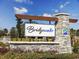 Elegant Bridgewater community entrance sign with stone accents, landscaping, and clear branding against a blue sky at 3105 White Jasmine Dr., Little River, SC 29566