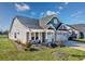 Beautiful exterior of a light gray home with a manicured lawn, lush landscaping and attached two car garage at 3105 White Jasmine Dr., Little River, SC 29566