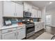 Modern kitchen with stainless steel appliances, gray subway tile backsplash, white cabinets, and hardwood floors at 3105 White Jasmine Dr., Little River, SC 29566