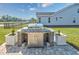 Backyard kitchen features an outdoor gas grill and granite countertop with white flowerpots at 3105 White Jasmine Dr., Little River, SC 29566