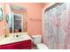 Bright bathroom with a pink color scheme, toilet, shower with curtain, and vanity with a mirror at 311 51St Ave. N, North Myrtle Beach, SC 29582