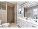 A remodeled bathroom featuring double sinks, tiled shower, modern fixtures, and decorative wallpaper at 311 51St Ave. N, North Myrtle Beach, SC 29582