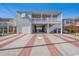 Two-story home with a garage and covered parking, featuring a patterned brick and concrete driveway at 311 51St Ave. N, North Myrtle Beach, SC 29582