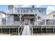 Elevated waterfront home showcasing white railings, open deck, and a private ramp for easy access to the water at 311 51St Ave. N, North Myrtle Beach, SC 29582