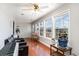 A cozy sunroom features a piano, seating, wood flooring, and bright windows providing natural light at 311 51St Ave. N, North Myrtle Beach, SC 29582