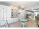 Bright dining area with glass table, white cabinets, a chandelier, and views into the kitchen at 354 Deer Run Ave., Georgetown, SC 29440