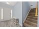 Bright foyer featuring wood-look flooring, a staircase, coat closet, and a white storage cabinet at 357 Cabo Loop, Myrtle Beach, SC 29588