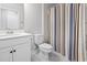 Bright bathroom featuring a white vanity, toilet, and blue striped shower curtain at 360 Cattle Drive Circle, Myrtle Beach, SC 29588