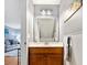 Bright bathroom with wood vanity, wainscoting, and decorative wall art at 404 72Nd Ave. N # 203, Myrtle Beach, SC 29572