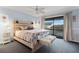 Comfortable bedroom featuring a wooden headboard, ceiling fan, and sliding glass doors to a private balcony at 404 72Nd Ave. N # 203, Myrtle Beach, SC 29572