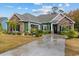 Charming green and stone house with a well manicured lawn and a concrete driveway at 405 Palo Verde Dr., Myrtle Beach, SC 29579