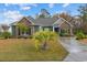 Charming green and stone house with a well manicured lawn and a concrete driveway at 405 Palo Verde Dr., Myrtle Beach, SC 29579