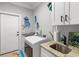 A practical laundry room features ample counter space, sink, cabinetry, and front load washer and dryer at 405 Palo Verde Dr., Myrtle Beach, SC 29579