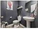 Chic powder room featuring dark gray walls, pedestal sink, round mirror and modern fixtures at 4092 Bayhill St., Myrtle Beach, SC 29579