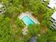 Aerial view showcasing a serene pool area surrounded by lush trees and condo buildings at 415 Ocean Creek Dr. # 2359, Myrtle Beach, SC 29572