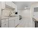 An efficient kitchen featuring white cabinets, stainless steel sink, and modern faucet, open to the living area at 4150 Horseshoe Rd. # 33, Little River, SC 29566