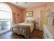 Comfortable bedroom features a large window, hardwood floors, and floral bedding at 4244 Luck Ave., Little River, SC 29566