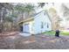 Detached garage featuring a roll-up door and side entrance, set in a wooded lot at 4244 Luck Ave., Little River, SC 29566