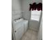 Laundry room with tiled floors, stacked washer and dryer, and storage shelves at 4340 Grande Harbour Blvd., Little River, SC 29566