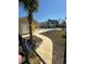 Community pool with a winding walkway, fenced perimeter, palm tree accents, and colorful surrounding buildings at 4340 Grande Harbour Blvd., Little River, SC 29566